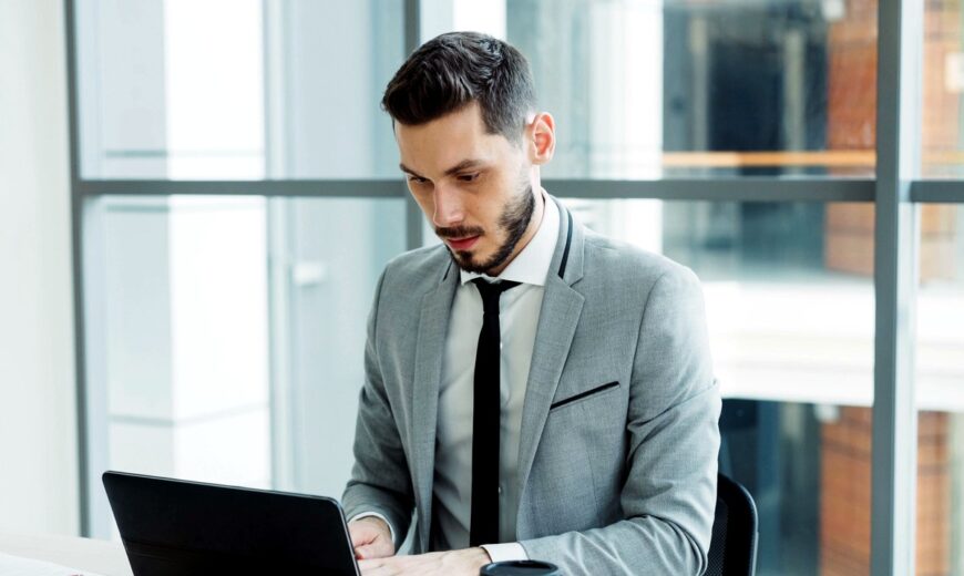Profesional de TI trabajando en su computador en una oficina moderna, revisando la estrategia de backup de la empresa