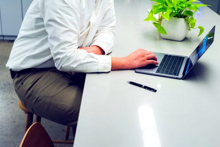 Profesional trabajando en computador portátil en modalidad remota, representando la ciberseguridad en el trabajo remoto e híbrido