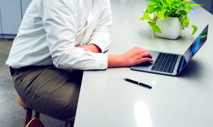 Profesional trabajando en computador portátil en modalidad remota, representando la ciberseguridad en el trabajo remoto e híbrido