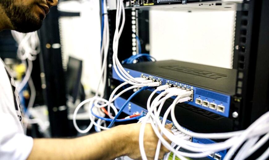 Técnico organizando y conectando cables de red en un switch empresarial dentro de un rack de infraestructura de red